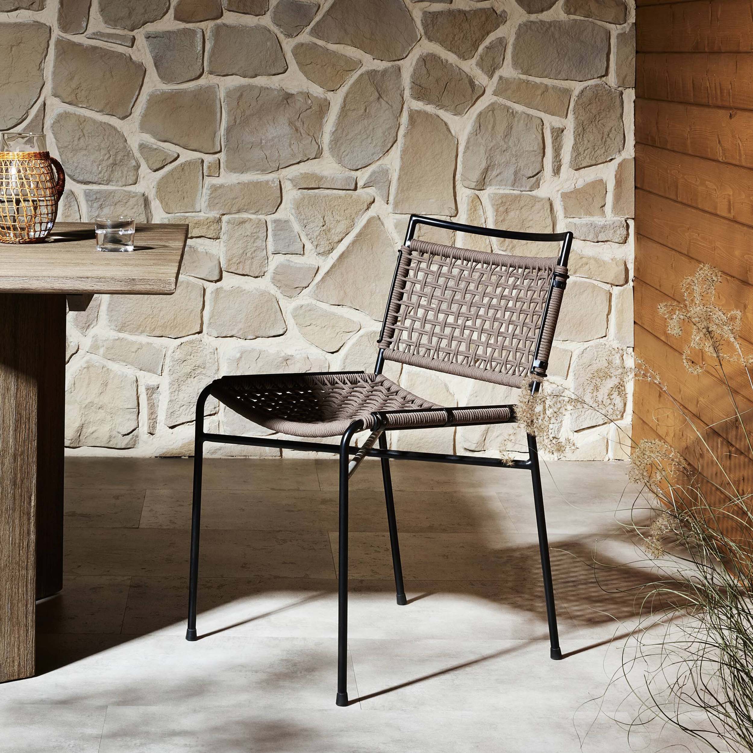 Wharton Outdoor Dining Chair, Earth Rope, Set of 2 in a modern outdoor setting with stone wall background.