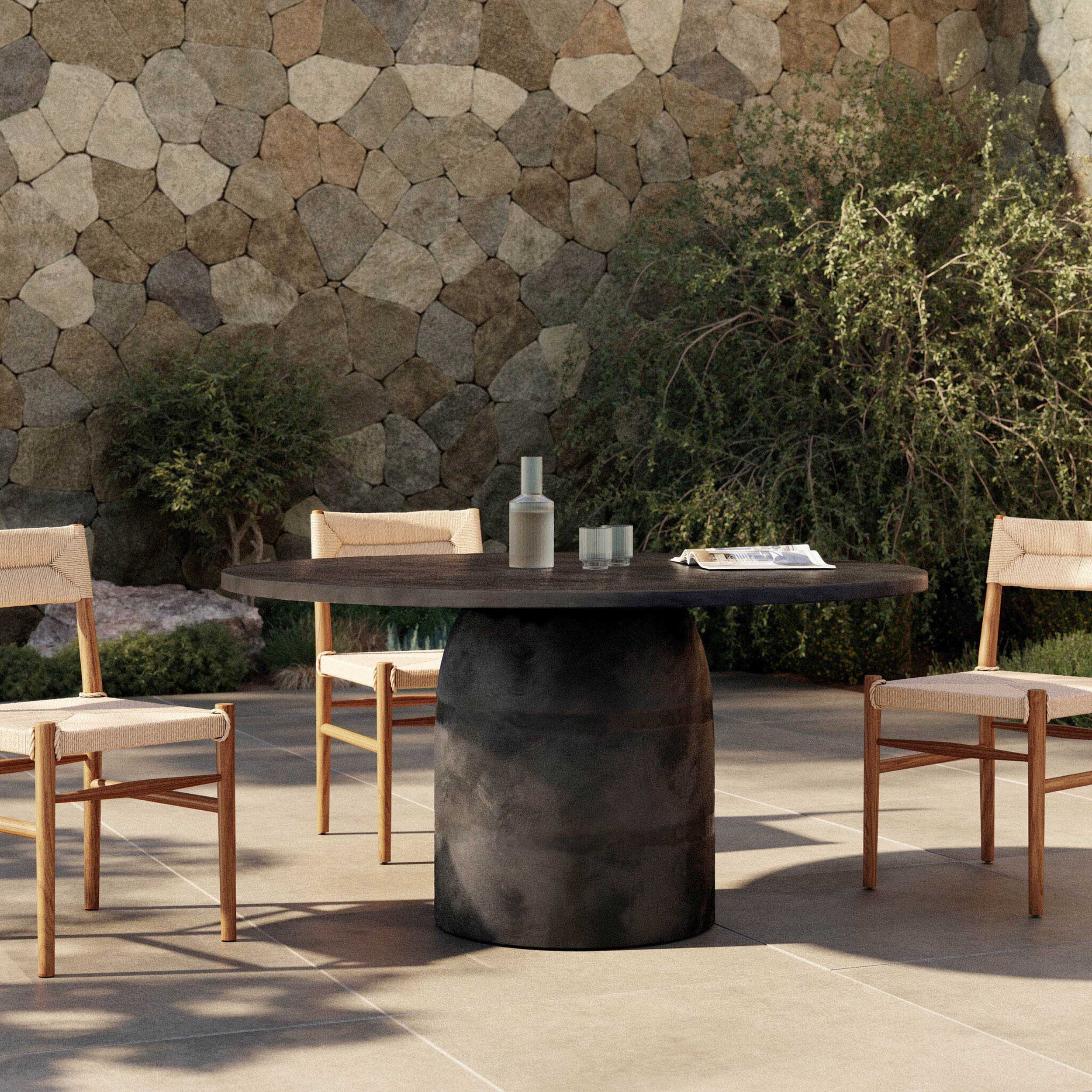 Basil Outdoor Dining Table 60", Aged Grey, featuring a sleek pedestal base in outdoor setting with chairs.
